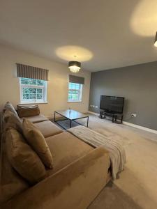 a living room with a couch and a flat screen tv at Luxury countryside stay - Waters Upton, Telford in Telford