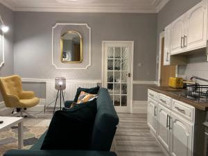 a living room with a blue couch and a kitchen at Flat 1 in Nottingham
