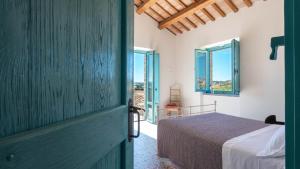 Un dormitorio con una cama en una habitación con ventanas. en La Buona Maniera, en Monteprandone