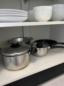 drei Töpfe und Pfannen auf einem Regal in einer Küche in der Unterkunft F2 à 12 mn de Paris avec Sauna - Parking privé in Argenteuil + 9 Fotos
