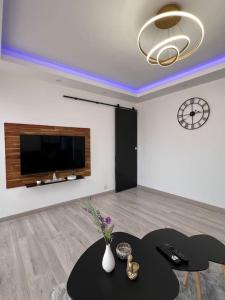 ein Wohnzimmer mit einem Tisch und einer Uhr an der Wand in der Unterkunft F2 à 12 mn de Paris avec Sauna - Parking privé in Argenteuil