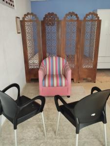 two chairs and a pink chair in a room at Lumiar Garden Suítes e Chalés em Vilas do Atlântico in Lauro de Freitas