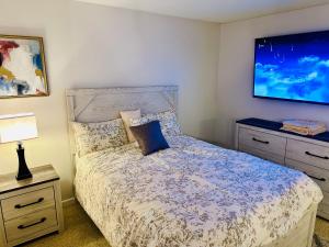 Un dormitorio con una cama y un televisor en la pared. en Mid-City Charm 2BR Near LAs Hotspots!, en Los Ángeles
