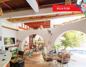 Un restaurante con mesas y sillas y una piscina. en Villa Flor Acapulco, en Acapulco