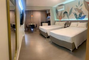 a hotel room with two beds and a table at Garvey Park Hotel - Ap 510 ou 512 in Brasilia