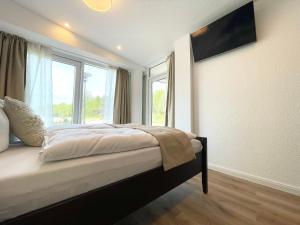 une chambre avec un lit et une grande fenêtre dans l'établissement Haus-Nordseebrandung-FeWo-9, à Cuxhaven 10 autres photos