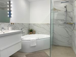 une salle de bain avec une baignoire, un lavabo et une douche dans l'établissement Haus-Nordseebrandung-FeWo-9, à Cuxhaven