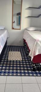 ein Zimmer mit einem Bett und einem Spiegel und einem Fliesenboden in der Unterkunft Apto Completo Aparecida de Goiânia in Aparecida de Goiania