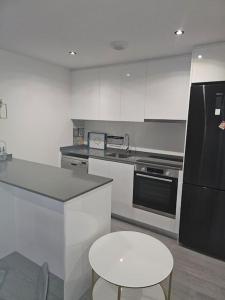 een keuken met een zwarte koelkast en een kruk bij Appartement Mijas in Mijas Costa