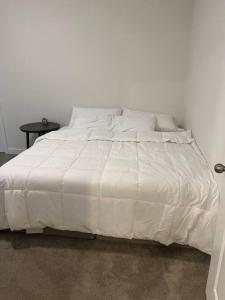 a white bed with a white comforter on it at A cozy house in Parker, Colorado in Parker