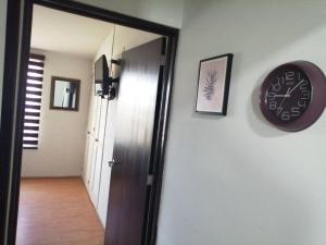 a clock on a wall next to a door at Departamento Ciudad del Valle B in Tepic