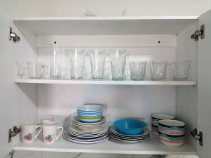 a shelf with plates and bowls and glasses on it at Departamento Ciudad del Valle B in Tepic
