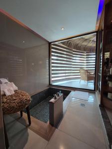 a room with a tub with a bed and a chair at Thai Lagoon in Laurel de Lagunillas