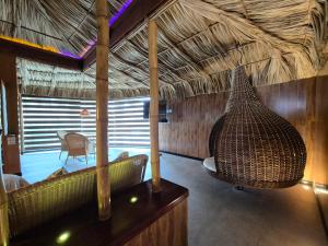 a living room with a couch and a straw roof at Thai Lagoon in Laurel de Lagunillas +1 photo