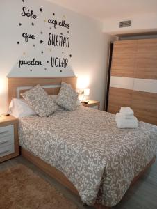 a bedroom with a bed with words on the wall at Apartamento con Jacuzzi El Rincón de las Delicias in Zaragoza