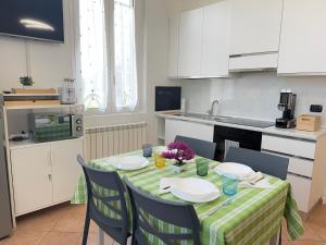 een keuken met een tafel met borden en bloemen erop bij 10' Malpensa Airport, alongside Train Station in Casorate Sempione