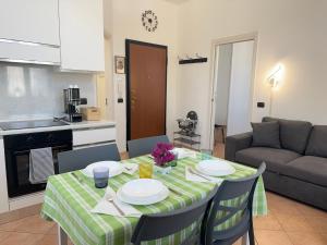 een woonkamer met een tafel en een keuken bij 10' Malpensa Airport, alongside Train Station in Casorate Sempione