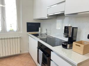 een keuken met een spoelbak en een aanrechtblad bij 10' Malpensa Airport, alongside Train Station in Casorate Sempione