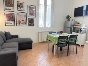 een woonkamer met een tafel en een bank bij 10' Malpensa Airport, alongside Train Station in Casorate Sempione