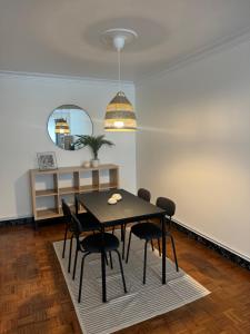 a dining room with a black table and chairs at As Travesas II in Betanzos