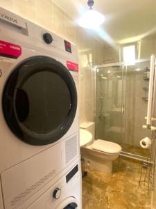a microwave in a bathroom with a toilet and a shower at Panoramik deniz manzaralı dubleks in Adalar