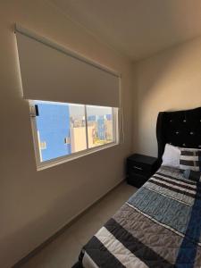 ein Schlafzimmer mit einem Fenster mit einem Bett und einer Aussicht in der Unterkunft Cómodo depto Cerca al mar y cerca de Aeropuerto in Gallinero + 4 Fotos