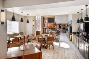 a restaurant with tables and chairs and a kitchen at Best Western Holiday Hills in Coalville