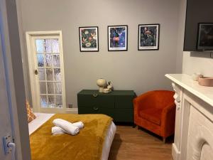 a bedroom with a bed and a chair and a window at Flat 1 in Nottingham