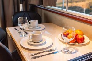 a table with two cups and a bowl of fruit at Cabana panorâmica in Cunha