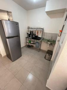 eine Küche mit Kühlschrank und Fliesenboden in der Unterkunft Cómodo depto Cerca al mar y cerca de Aeropuerto in Gallinero