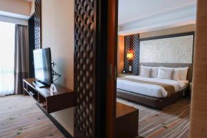 una habitación de hotel con una cama y un televisor en Best Western Plus The Ivywall Hotel - Palawan, en Puerto Princesa City