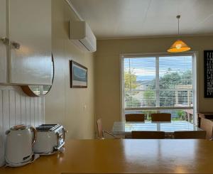 a kitchen with a table and a large window at Hennessy Beach House in Port Campbell