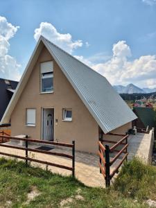 a house with a pitched roof and a fence at Guest House Tamara in Žabljak