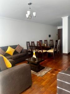 a living room with a couch and a table and chairs at El Hogar - Sucursal América - Edificio Ferrara 1228 con Garaje cubierta in Cochabamba