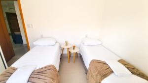 two beds in a hospital room with a table at Espaço Motta - Diamantina - MG in Diamantina