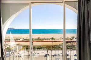 a window view of the beach from a hotel room at Apartamento Frente del Mar in Empuriabrava +20 photos