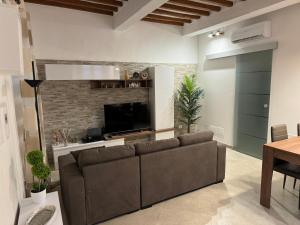 a living room with a couch and a tv at Onda di Porta a Mare in Livorno