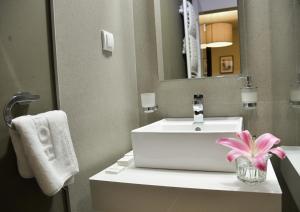 a bathroom with a white sink and a mirror at Hotel Sole in Niš