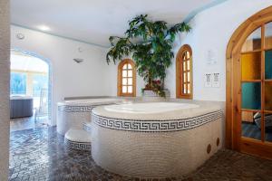un bagno con una grande vasca in una stanza di Hotel Haus Michaela a Sappada