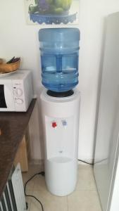 a water cooler with a blue container on top of it at Pequeño estudio muy lindo a 500 m de la playa in L'Escala