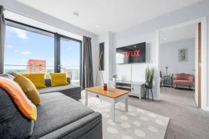 una sala de estar con un sofá y una mesa en Modern Apartment Central Manchester, en Mánchester