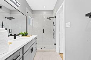 a white bathroom with a shower and a sink at Downtown Luxe Retreat - King Bed, Pool, Pong, Billiards, Grill & FREE Coffee in Houston +35 photos