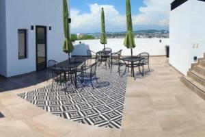 a patio with tables and chairs on top of a building at Stunning Oceanview apartment in Mazatlan in Mazatlán