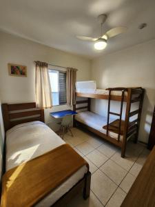 a bedroom with two bunk beds and a desk at Pousada Tokyo Plaza in Mogi das Cruzes