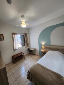 a bedroom with a bed and a desk and a window at Pousada Tokyo Plaza in Mogi das Cruzes +4 photos