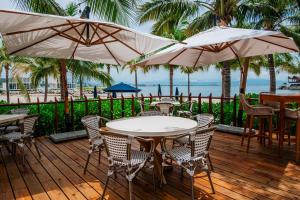 a wooden deck with tables and chairs and umbrellas at Tropical Oasis with cook and Housekeeping service INCLUDED Private Pool BBQ Beach Access in Cruz de Huanacaxtle +54 photos