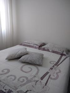 a bed with two pillows on it in a bedroom at Apartamento Oktotoberfest Blumenau DAL in Blumenau