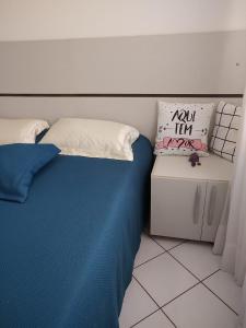 a bedroom with a bed with blue sheets and pillows at Apartamento Oktotoberfest Blumenau DAL in Blumenau