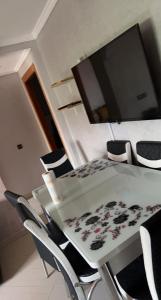 a dining room table with chairs and a television at Paysage del costa in Jbila