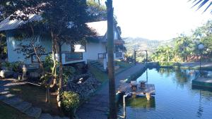a house next to a river with a table in the water at Chalé Girassol in Jaraguá do Sul